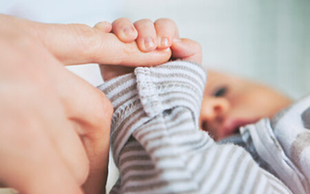 baby holding parents finger