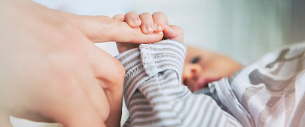 baby holding parents finger